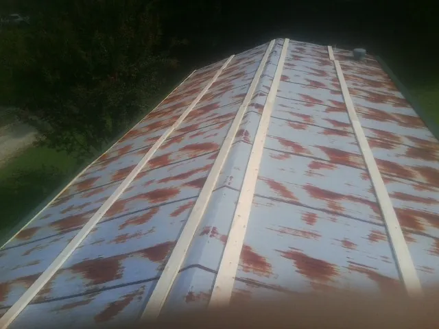 Rusted metal roof panels with new wood purlins before replacement — Storm Damage Roof Repair in Newton Hamilton by Roofing Brothers