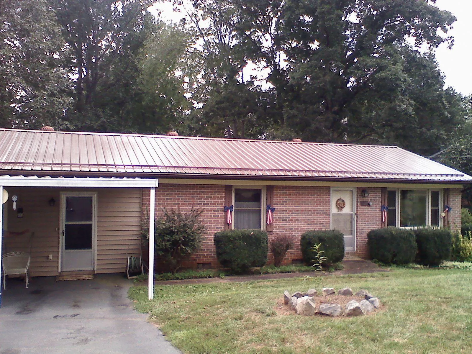 Bronze metal roof and carport on a brick ranch home — Roof Repair work by our crew in Newton Hamilton